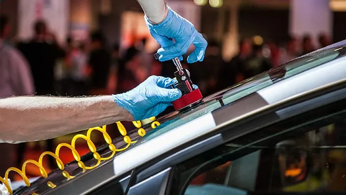 A stone chip repair being carried out on a vehicle windscreen