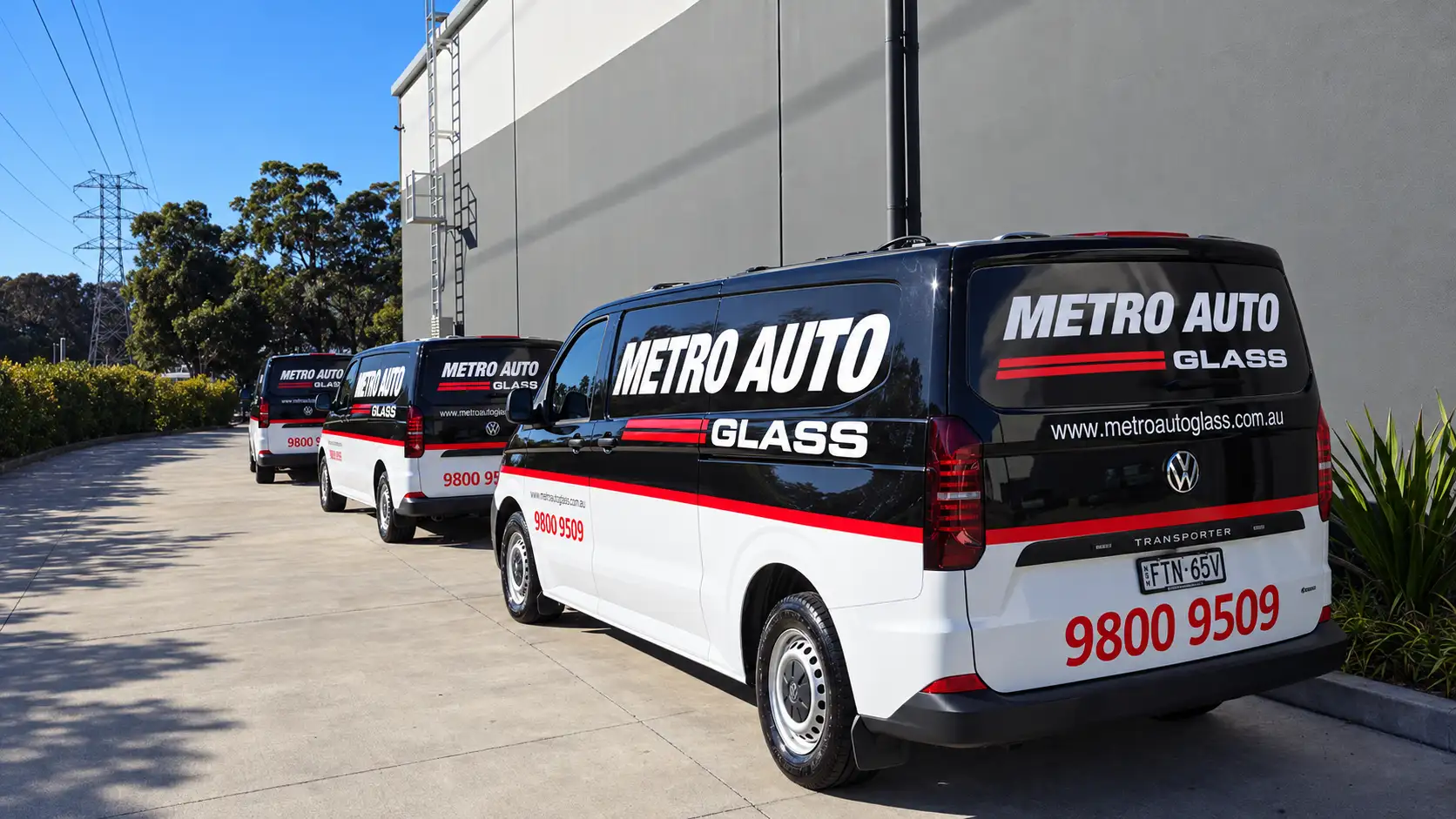 Three Metro Auto Glass vans parked in a row