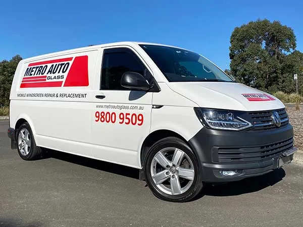 A Metro Auto Glass mobile van fitting a windscreen at a customer's address