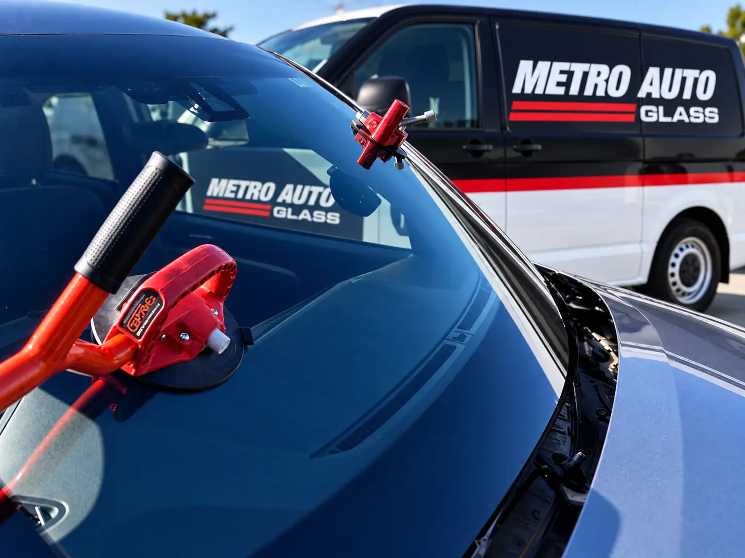 Windscreen being fitted with suction lifters, Metro Auto Glass van behind